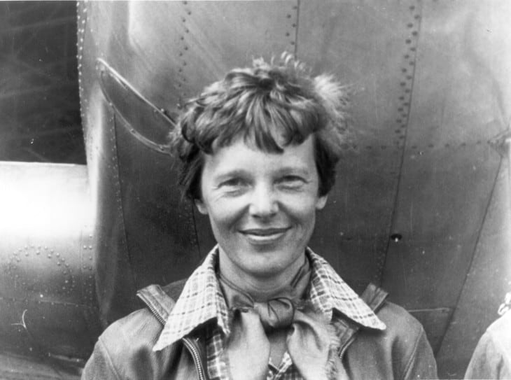 Amelia Earhart standing under nose of her Lockheed Model 10 E Electra